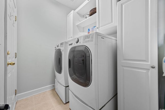 Laundry area with washer and dryer, cabinet space, and light tile patterned flooring | Image 37