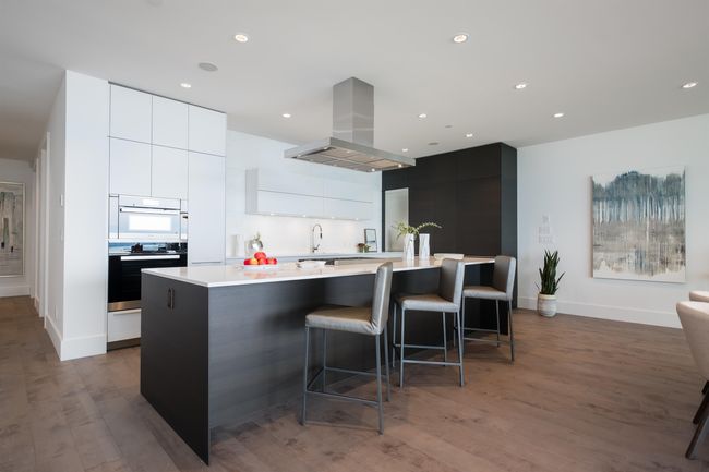 Kitchen featuring island exhaust hood, modern cabinets, light countertops, white cabinets, and a large island with sink | Image 15