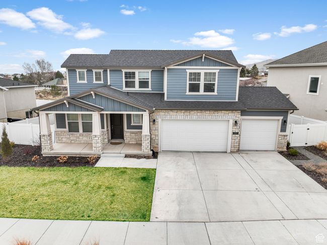 View of front facade featuring fence, a front yard, stone siding, and a porch | Image 24