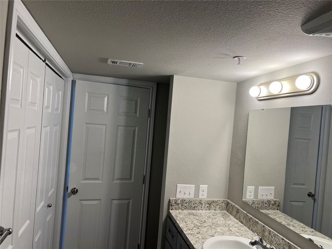 Bathroom with vanity, a textured ceiling, and a wall mounted AC | Image 10