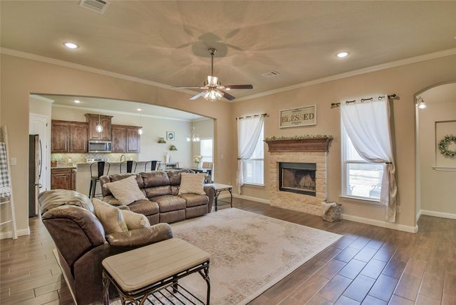 Living room featuring ceiling fan, arched walkways, and a healthy amount of sunlight | Image 4