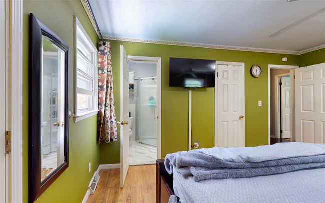 Bedroom with light wood-style floors, baseboards, and ensuite bath | Image 26
