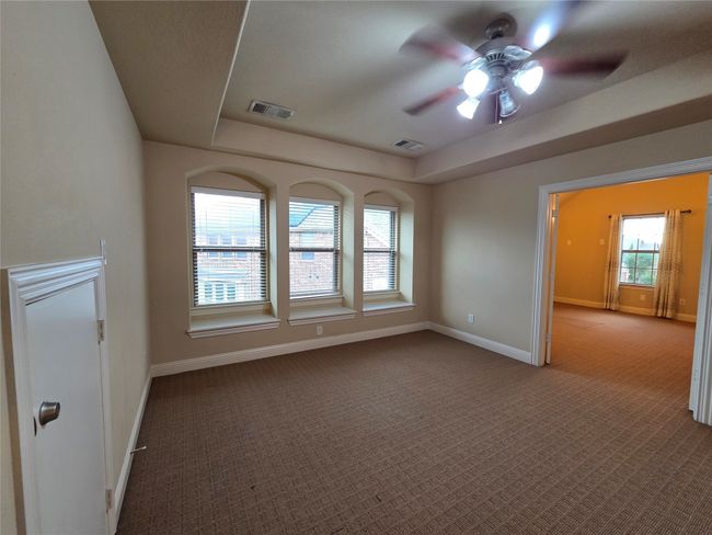 Unfurnished room featuring ceiling fan, a tray ceiling, and carpet floors | Image 34