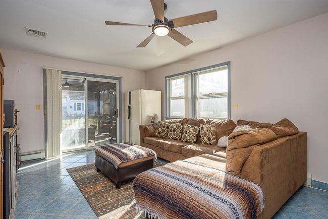 Family room featuring sliding doors to yard, tile patterned flooring, ceiling fan and baseboard | Image 24