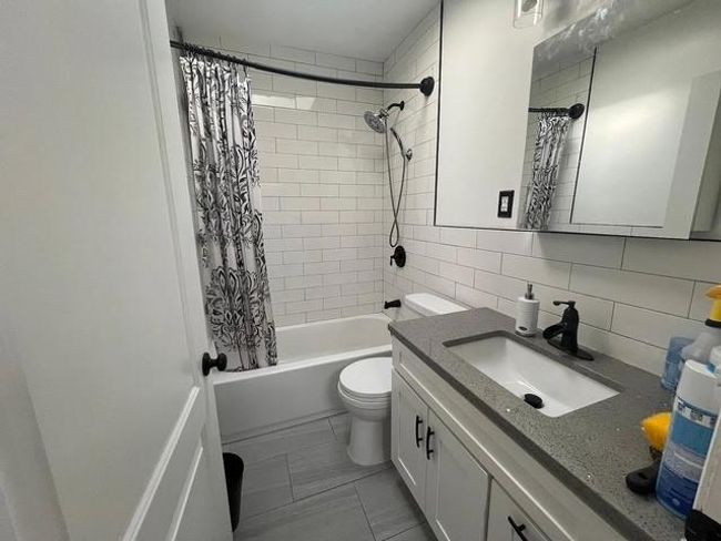 Full bath featuring vanity, shower / tub combo, and backsplash | Image 5