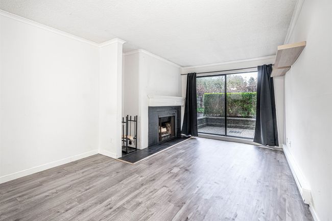 Unfurnished living room featuring crown molding, wood finished floors, a fireplace with raised hearth, and a textured ceiling | Image 10