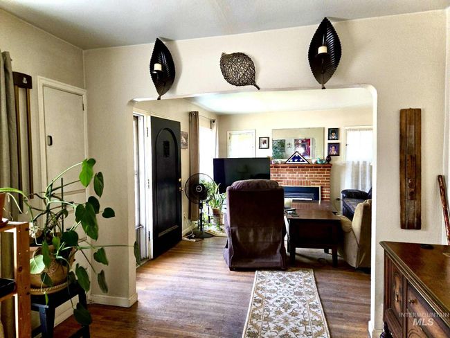 Office with arched walkways, dark wood-style floors, and a fireplace | Image 8