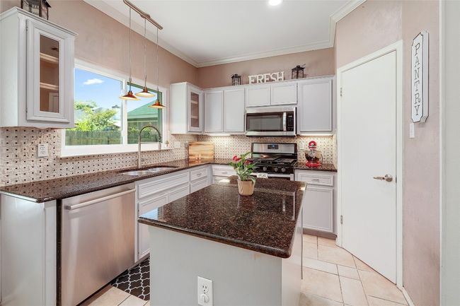 Kitchen featuring ornamental molding, a sink, backsplash, and stainless steel appliances | Image 10