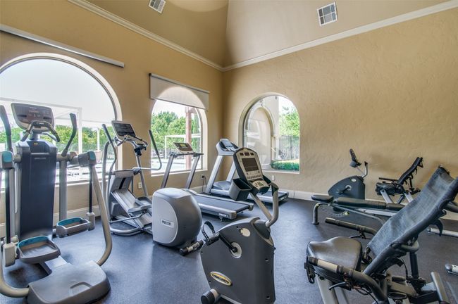Exercise room featuring a textured wall and a high ceiling | Image 28