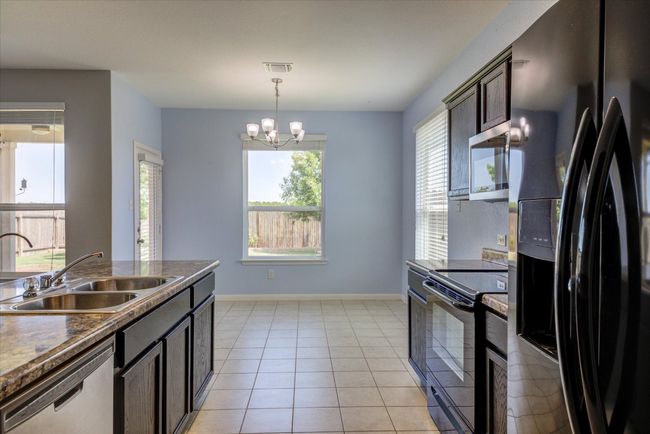 Picture taken from the laundry area looking through the kitchen to the eat-in dining space. | Image 10