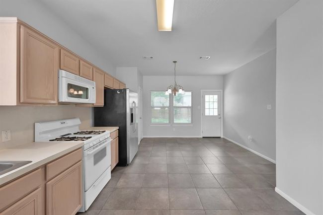 A large dining table could easily be accommodated, or a kitchen island could be added for extra countertop space. Dedicated pantry space can be found in the door next to the fridge. | Image 11
