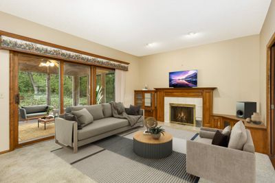 Family room adjoining kitchen leads out to nice 3-season porch and patio with fire pit. | Image 3