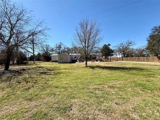 View of yard featuring a storage shed, fence, and an outbuilding | Image 6