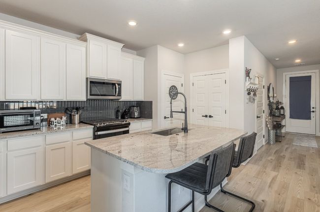 Kitchen with stainless steel appliances, decorative backsplash, Refrigerator conveys with sale. | Image 7
