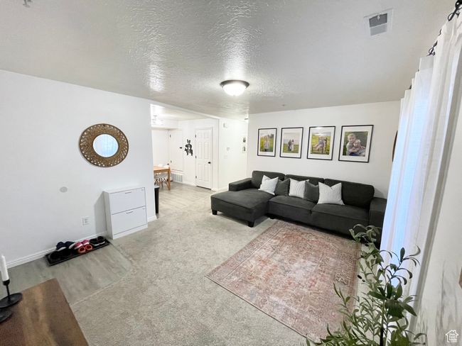 Living area with a textured ceiling and baseboards | Image 4