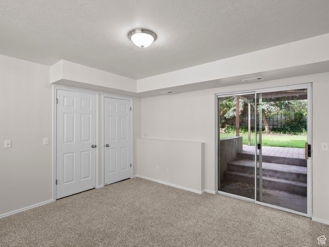 Unfurnished bedroom featuring access to exterior, carpet, baseboards, and a textured ceiling | Image 23