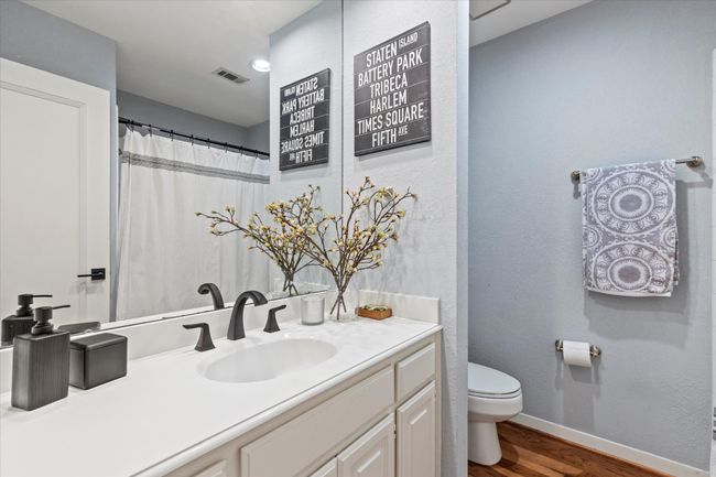 Bathroom featuring wood finished floors, toilet, vanity, baseboards, and a textured wall | Image 24