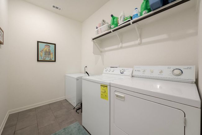 Laundry area featuring washing machine and clothes dryer and baseboards | Image 22