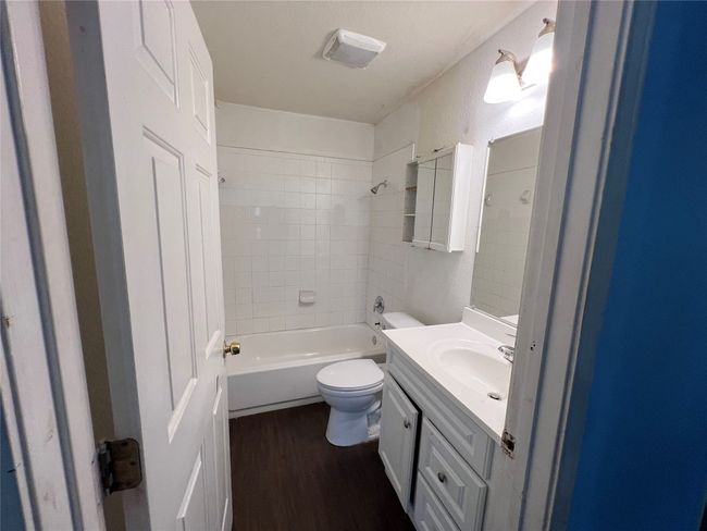 Full bathroom featuring wood finished floors, toilet, vanity, and bathtub / shower combination | Image 18