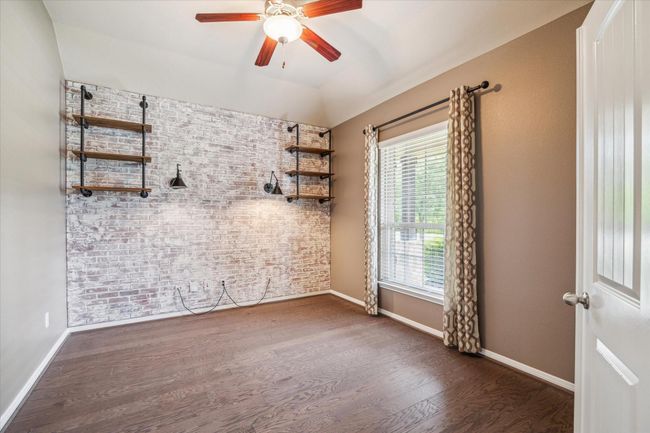 Versatile flex space with stylish sconces, built-in shelving, and ample natural light—ideal for a home office or creative studio. | Image 11