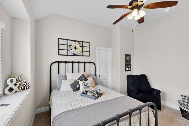 Bedroom featuring carpet, baseboards, lofted ceiling, and ceiling fan | Image 22