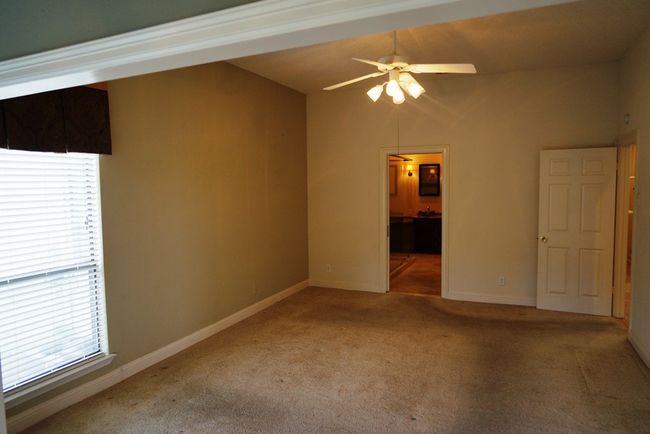 Carpeted empty room with ceiling fan, plenty of natural light, and baseboards | Image 13