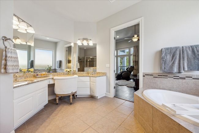 Full bath with a bath, a shower stall, tile patterned floors, a ceiling fan, and vanity | Image 16
