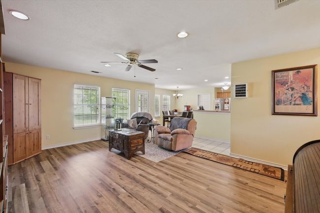 Living area with baseboards, recessed lighting, visible vents, light wood finished floors, and ceiling fan with notable chandelier | Image 8