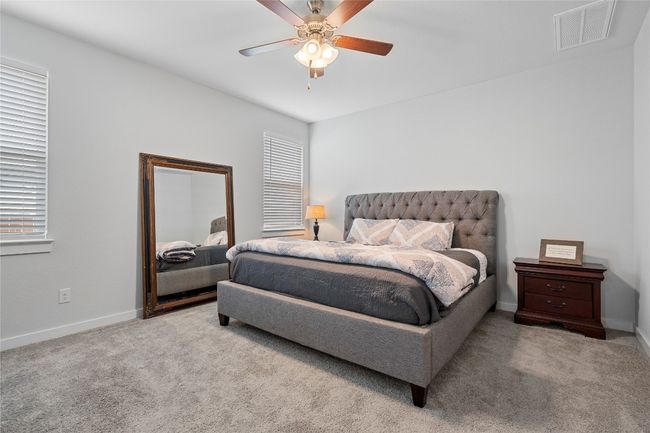 Carpeted bedroom featuring multiple windows, baseboards, and a ceiling fan | Image 18