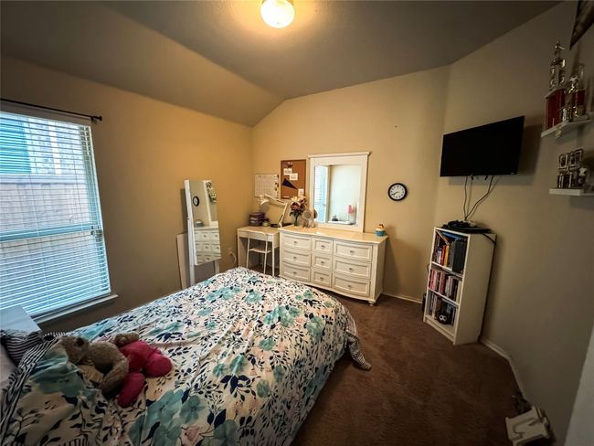 Bedroom with baseboards, dark colored carpet, and vaulted ceiling | Image 14
