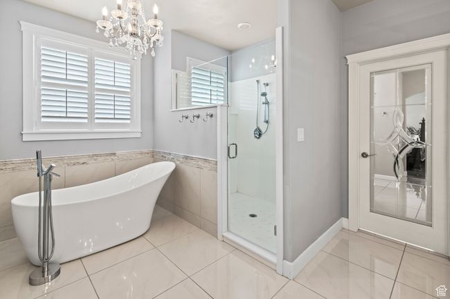 Bathroom with tile patterned floors, independent shower and bath, and an inviting chandelier | Image 48