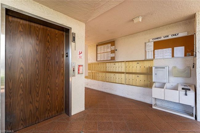 Hallway with elevator, a textured wall, mail area, and a textured ceiling | Image 27