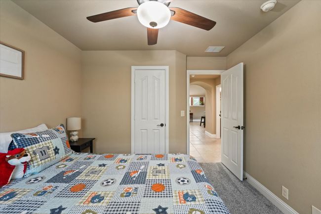 Bedroom with arched walkways, visible vents, baseboards, and ceiling fan | Image 27