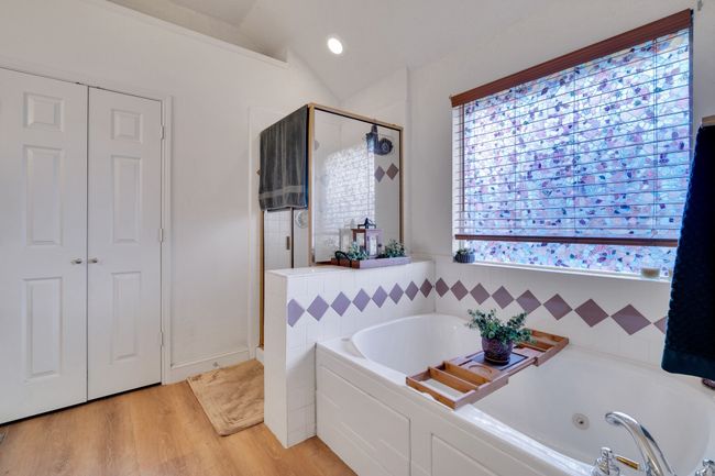 Bathroom featuring a shower stall, a whirlpool tub, wood finished floors, lofted ceiling, and recessed lighting | Image 28