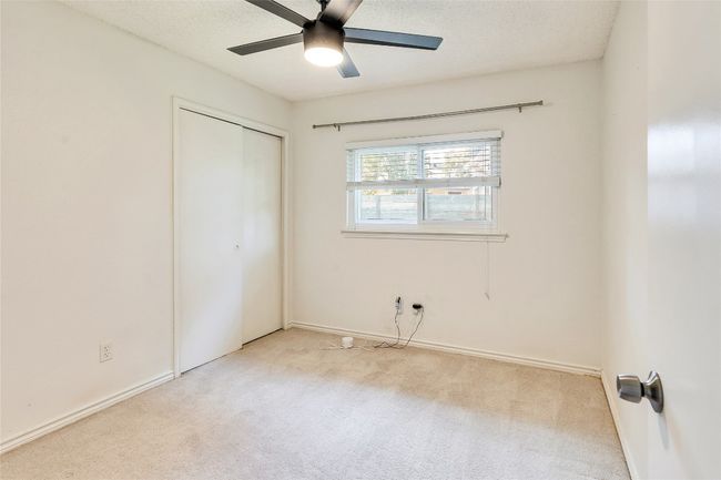 Unfurnished bedroom featuring carpet, a closet, a textured ceiling, and a ceiling fan | Image 9