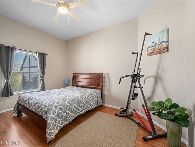 Bedroom with a ceiling fan, wood finished floors, and baseboards | Image 44