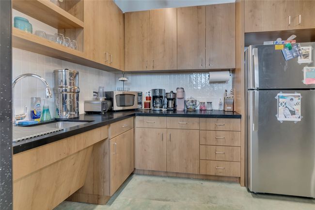 Kitchen featuring appliances with stainless steel finishes, decorative backsplash, open shelves, and light brown cabinets | Image 14