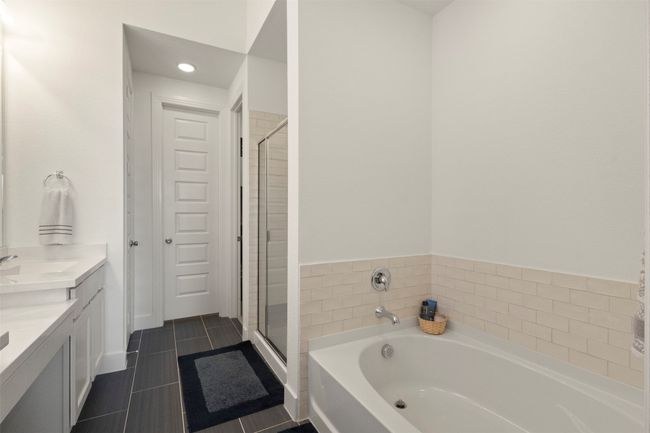 Full bathroom featuring a bath, double vanity, a stall shower, tile patterned floors, and recessed lighting | Image 8