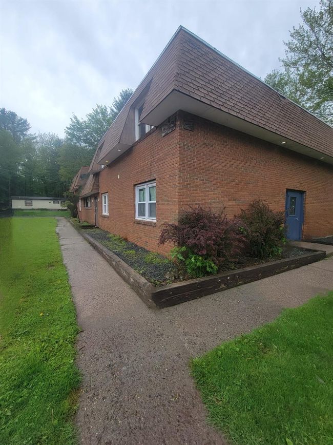 View of side of property featuring brick siding and mansard roof | Image 19
