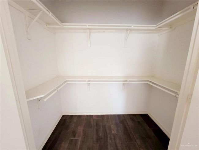 Walk in closet featuring dark wood-type flooring | Image 17