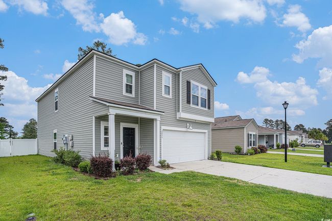 Traditional-style home with a garage and concrete driveway | Image 7