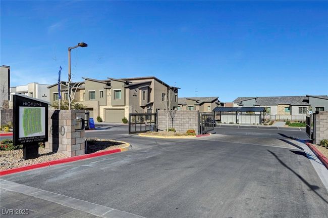 View of street with a gated entry, a residential view, a gate, curbs, and street lights | Image 48