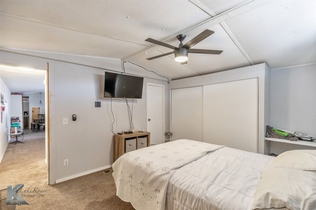 Bedroom with baseboards, vaulted ceiling, light carpet, a closet, and a ceiling fan | Image 15