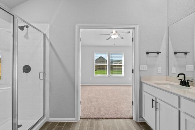 Full bathroom featuring vanity, baseboards, a stall shower, a ceiling fan, and wood finished floors | Image 16