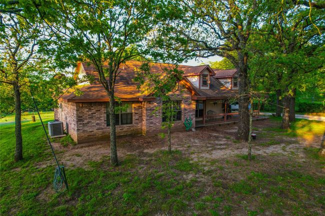 Rear view of property with covered porch, brick siding, and central AC unit | Image 26