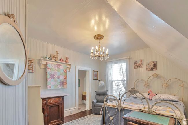Bedroom with vaulted ceiling, a notable chandelier, and hardwood / wood-style flooring | Image 26