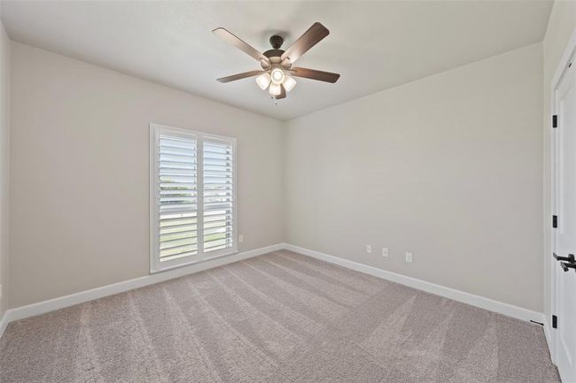 secondary bedroom with ceiling fan | Image 18