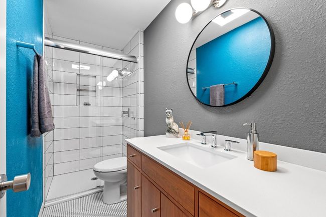 The spa-like wall-in shower is surrounded in gorgeous tile backsplash and comes with a glass door and an updated Kohler shower pan. | Image 35