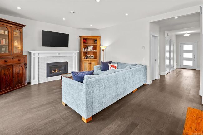 Living room featuring dark wood-style floors, recessed lighting, and a fireplace | Image 12