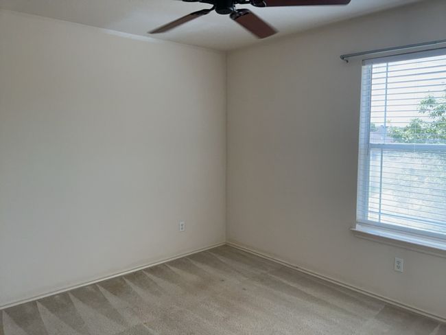 Bedroom featuring a ceiling fan and light colored carpet | Image 12
